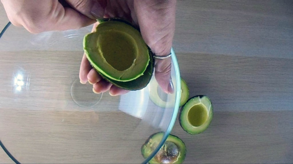 Scoop out the avocado flesh into a large mixing bowl.