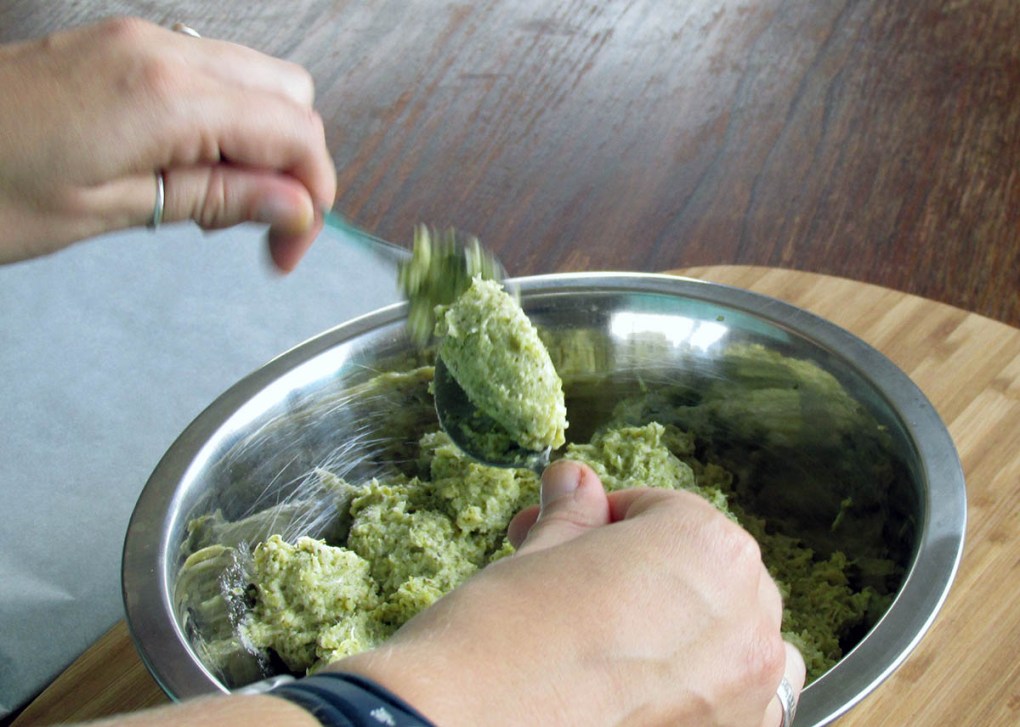 Taking the second spoon, push the portion off the first spoon.