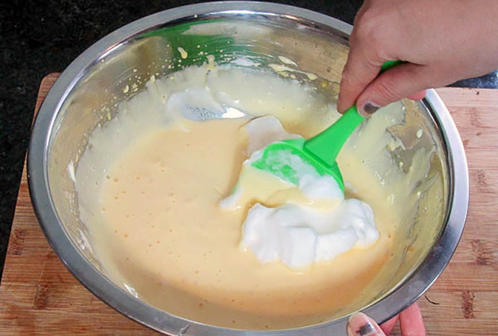 Slowly fold the egg whites into the egg yolk mixture, try not to break down the egg whites too much.