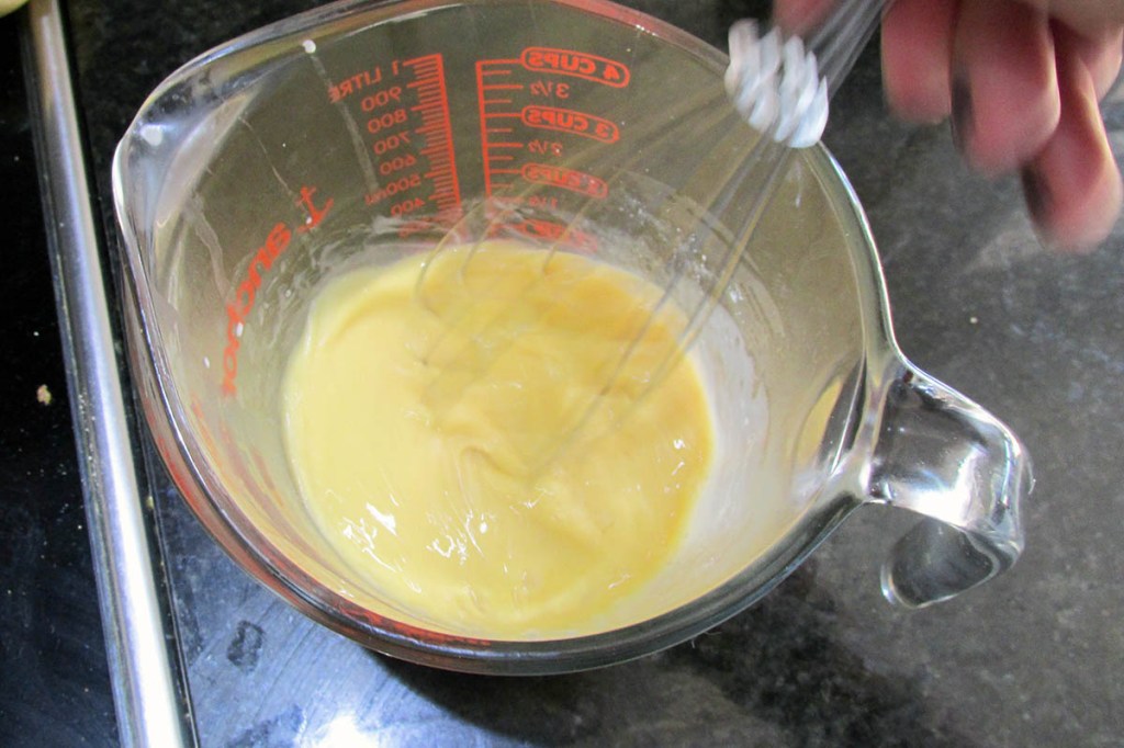 Add three tablespoons of the milk mix to the eggs and whisk.